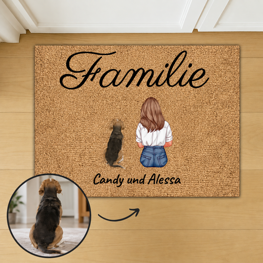 Gepersonaliseerde kokosvezelmat met het woord "Familie" en illustraties van een vrouw en een hond.