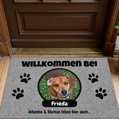 Gepersonaliseerde grijze deurmat met foto van een hond en naambordje met zwarte tekst.