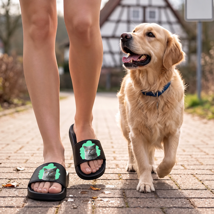Gepersonaliseerde zwarte badslippers met kattenportret, gedragen door iemand die een hond uitlaat.