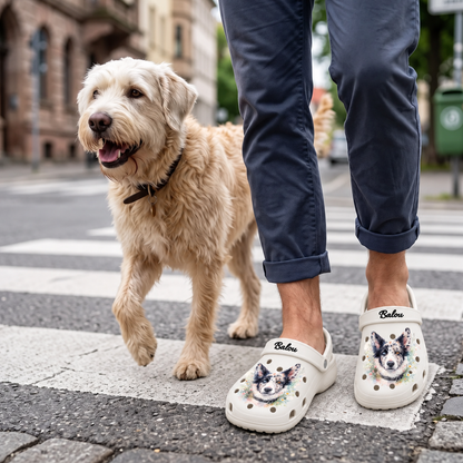 Persoon draagt gepersonaliseerde klompen met aquarel-hondenmotief en wandelt met een hond.